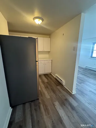 a view of utility room with closet and wooden floor