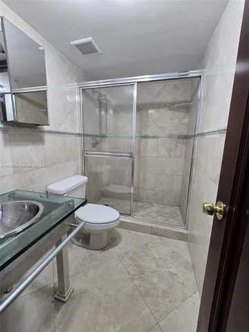 a bathroom with a sink a toilet and a shower