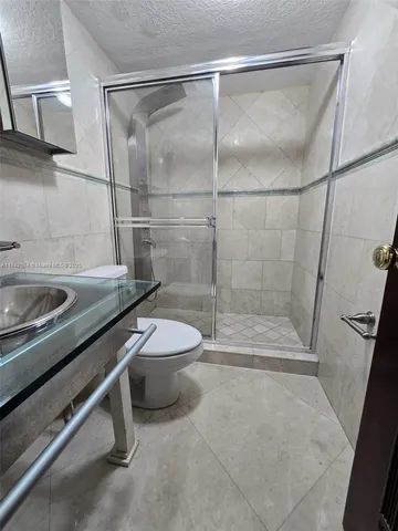 a bathroom with a shower a toilet and a sink