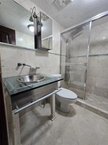 a bathroom with a granite countertop sink a toilet and a mirror