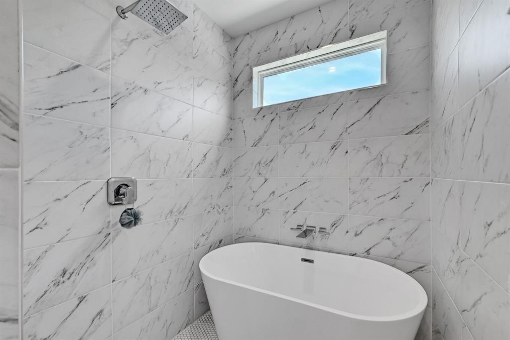 2812 East 4th Street, Unit 2 Austin, TX 78702 - Photo 20 of 26 Bathroom featuring large format marble-look wall tiles, a freestanding soaking tub