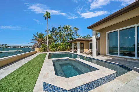 a large kitchen with a large counter top a stove a sink and a refrigerator