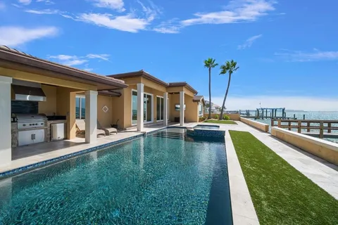 a view of a house with swimming pool and sitting area