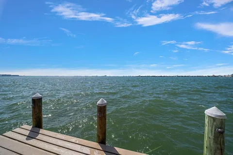 a kitchen with stainless steel appliances kitchen island granite countertop a stove a refrigerator a sink a oven and a microwave with wooden floor