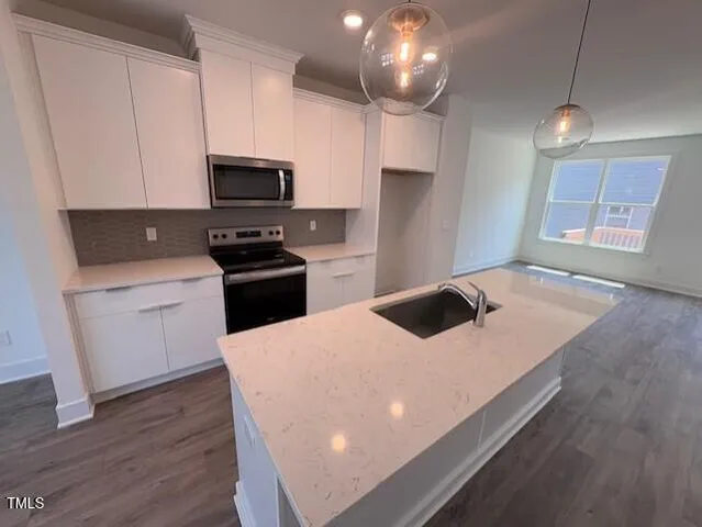 a kitchen with kitchen island a stove sink and microwave