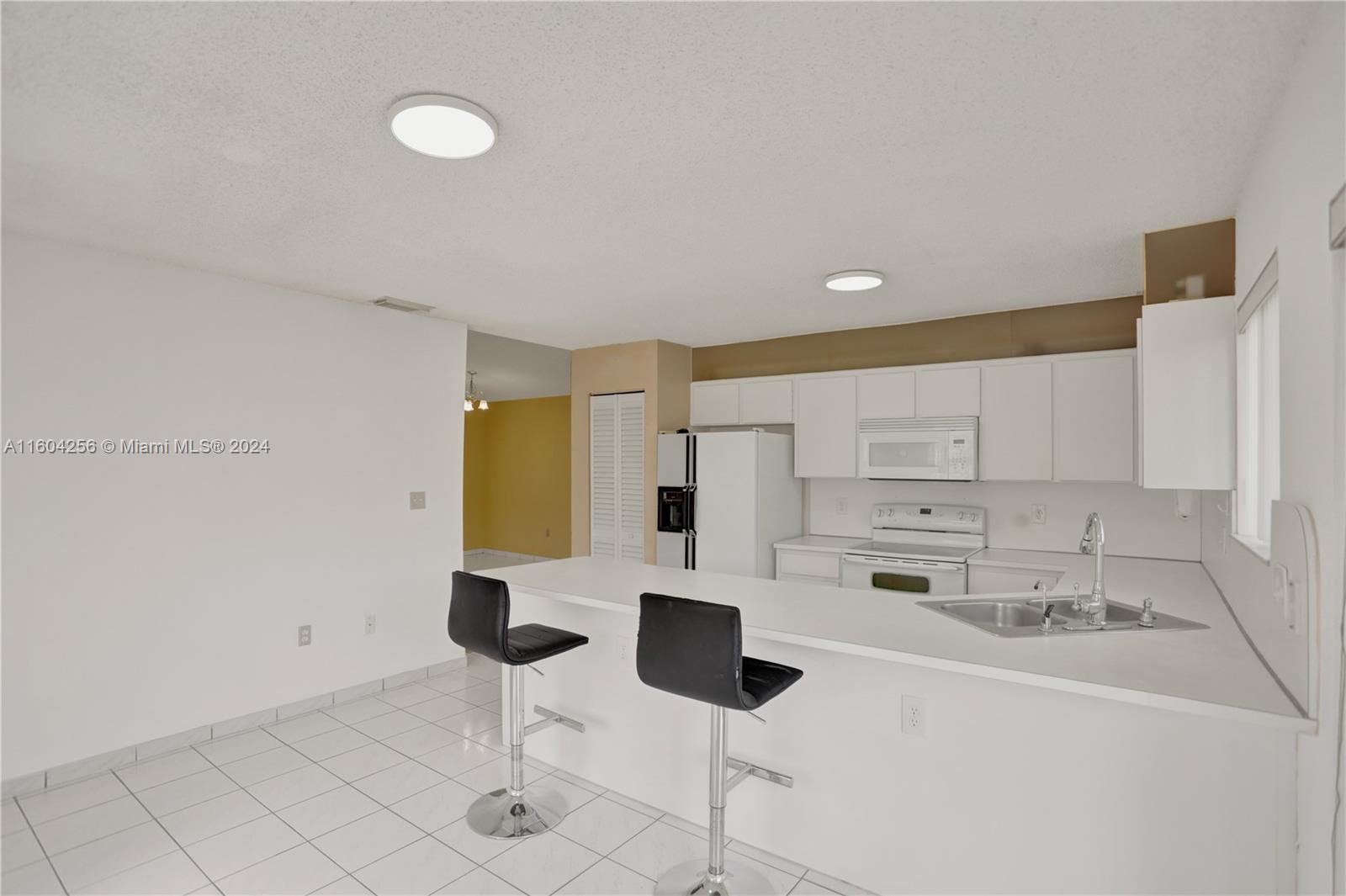 3131 West 79th Place Hialeah, FL 33018 - Photo 12 of 38 a kitchen with stainless steel appliances kitchen island a stove a table and chairs in it