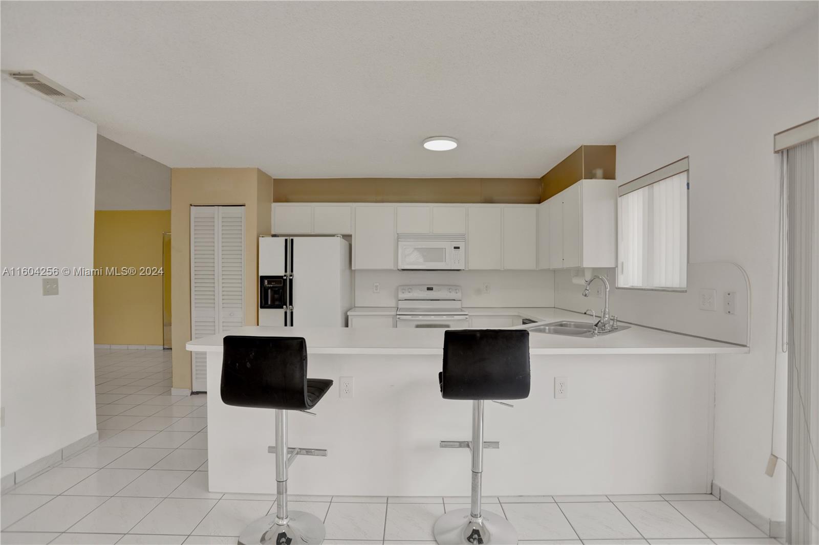 3131 West 79th Place Hialeah, FL 33018 - Photo 13 of 38 a kitchen with stainless steel appliances kitchen island granite countertop a stove a refrigerator a sink and white cabinets with wooden floor