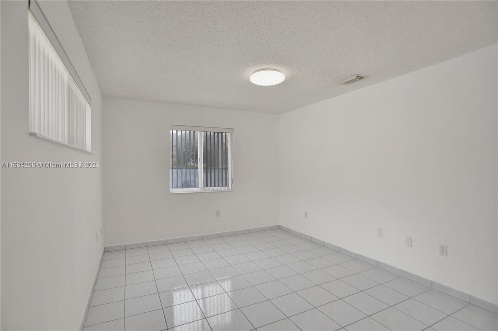 3131 West 79th Place Hialeah, FL 33018 - Photo 16 of 38 wooden floor in an empty room with a window