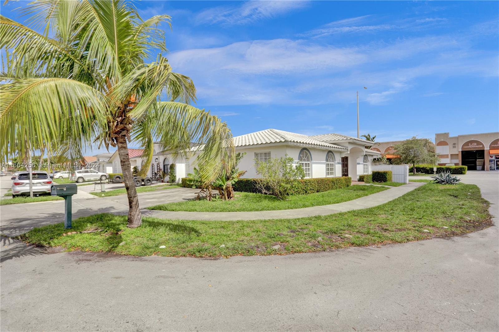 3131 West 79th Place Hialeah, FL 33018 - Photo 2 of 38 a view of a white house with a big yard and palm trees