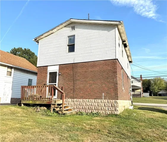 a view of a house with a yard and sitting area