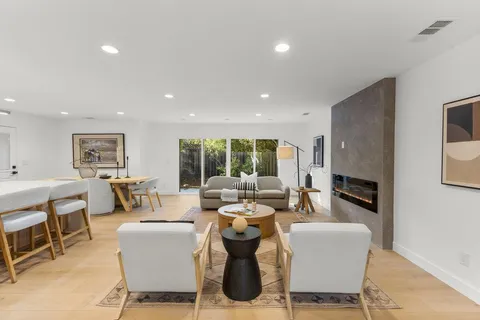 a living room with fireplace furniture and a large window