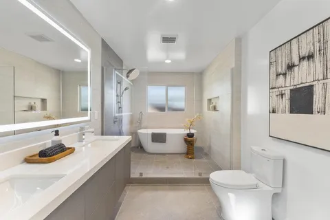 a bathroom with a sink a toilet and shower