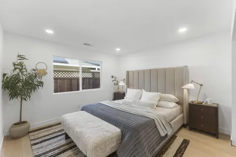 a bedroom with a bed and a potted plant