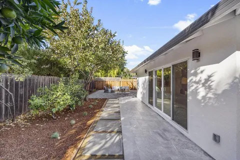 a backyard of a house with table and chairs
