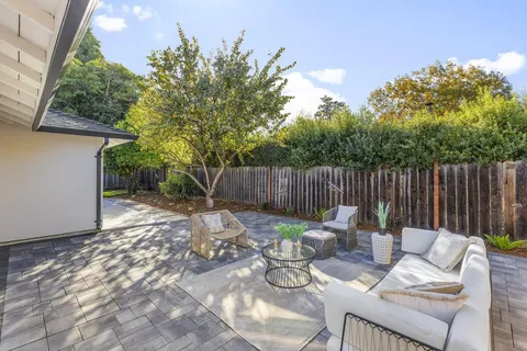 a backyard of a house with table and chairs
