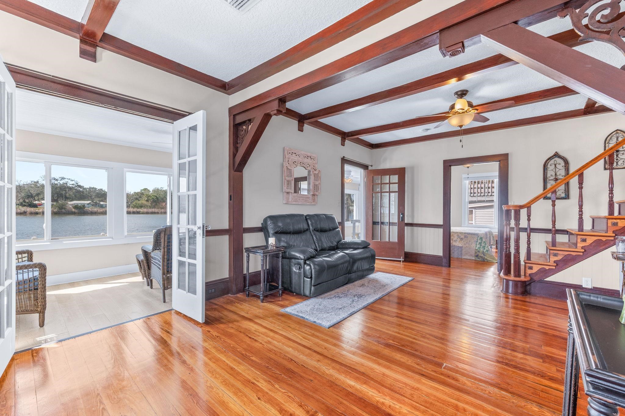 Living room with french doors, hardwood / wood-style floors, a ceiling fan, and beamed ceiling
