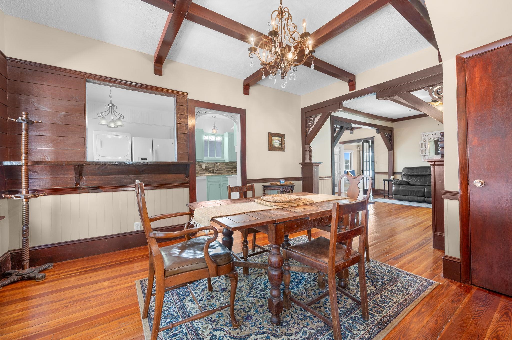 59 Lewis Boulevard St. Augustine, FL 32084 - Photo 12 of 75 Dining space with a chandelier, wood finished floors, beamed ceiling, a wainscoted wall, and wood walls