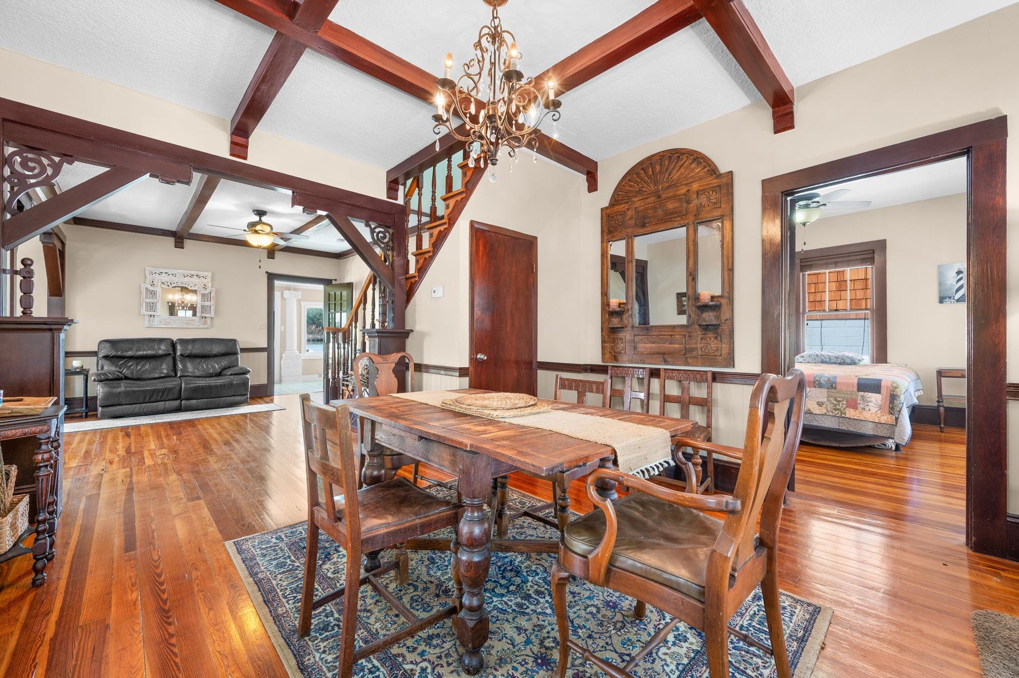 59 Lewis Boulevard St. Augustine, FL 32084 - Photo 13 of 75 Dining area featuring ceiling fan, beamed ceiling, wood-type flooring, and a chandelier