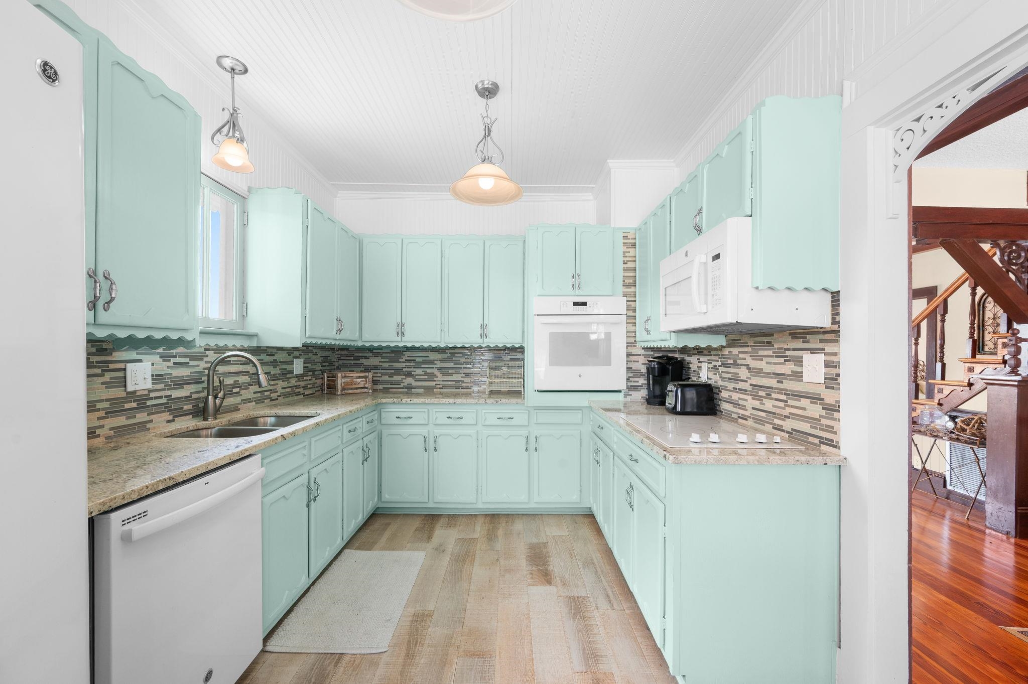 59 Lewis Boulevard St. Augustine, FL 32084 - Photo 16 of 75 Kitchen featuring white appliances, pendant lighting, light wood-style flooring, light stone counters, and ornamental molding