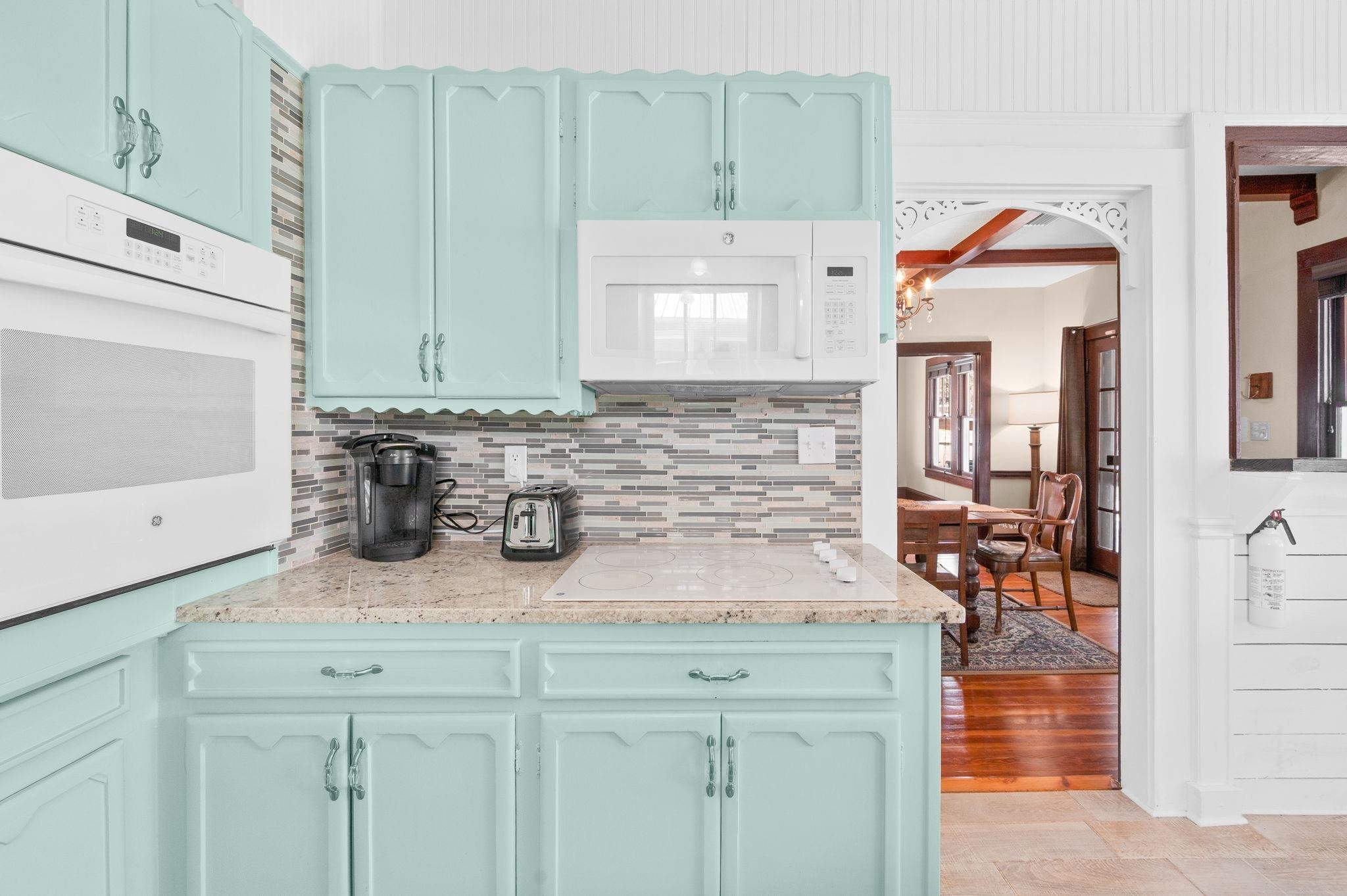 59 Lewis Boulevard St. Augustine, FL 32084 - Photo 19 of 75 Kitchen with white appliances, light stone counters, tasteful backsplash, beam ceiling, and arched walkways
