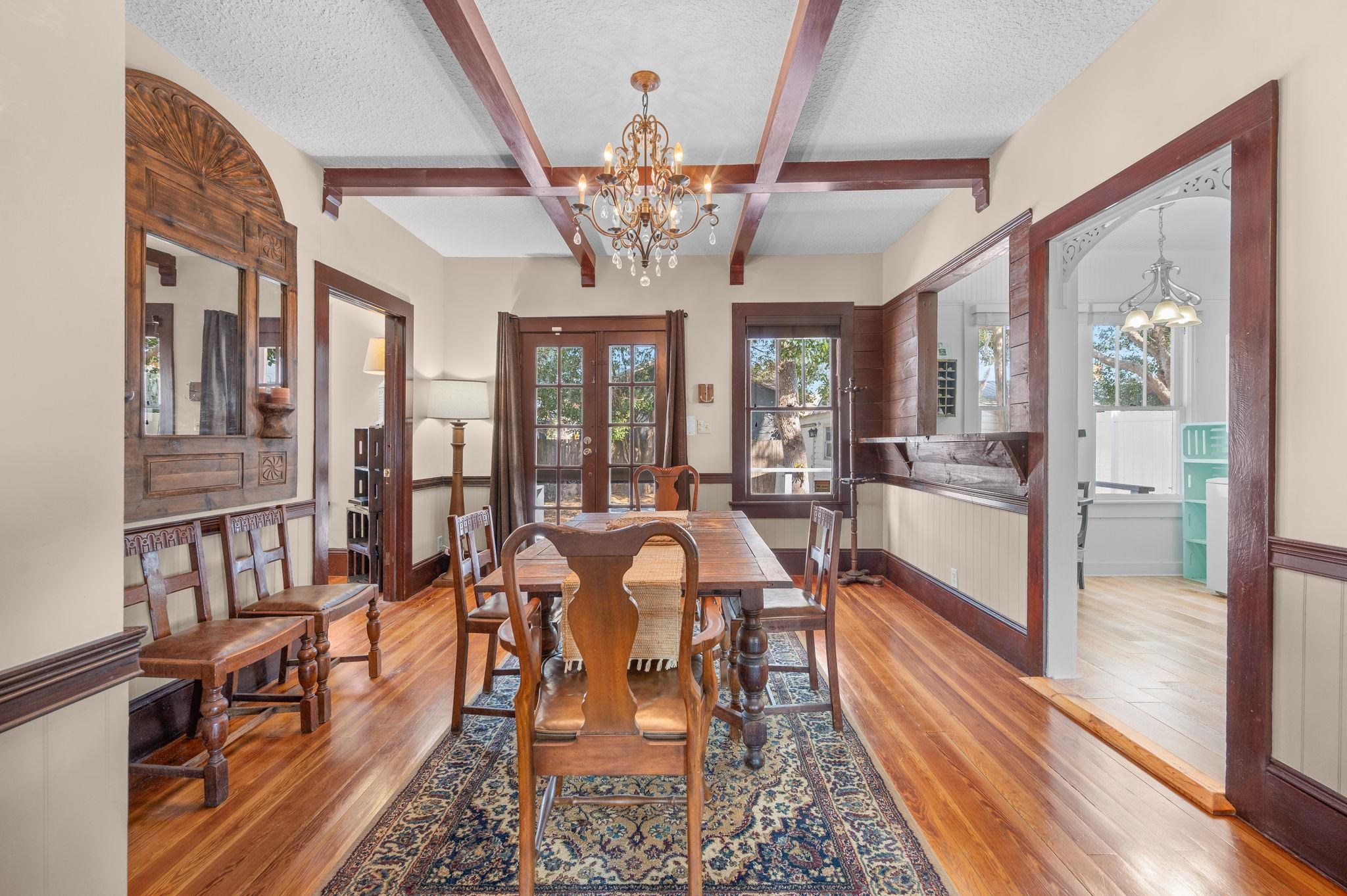 59 Lewis Boulevard St. Augustine, FL 32084 - Photo 70 of 75 Dining room with a chandelier, a textured ceiling, light wood-style floors, french doors, and a wainscoted wall
