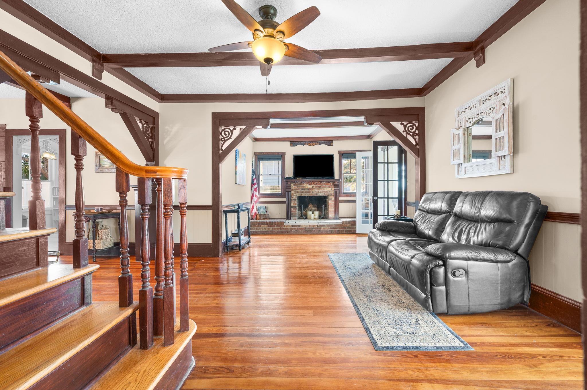 59 Lewis Boulevard St. Augustine, FL 32084 - Photo 75 of 75 Living room featuring light wood-type flooring, a fireplace, a ceiling fan, and wainscoting