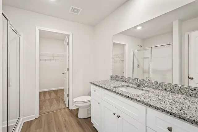 a bathroom with a granite countertop sink toilet and shower