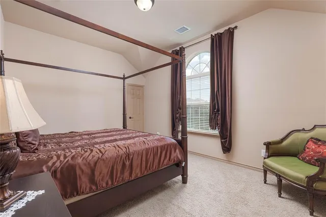 a bedroom with a bed and a table chair