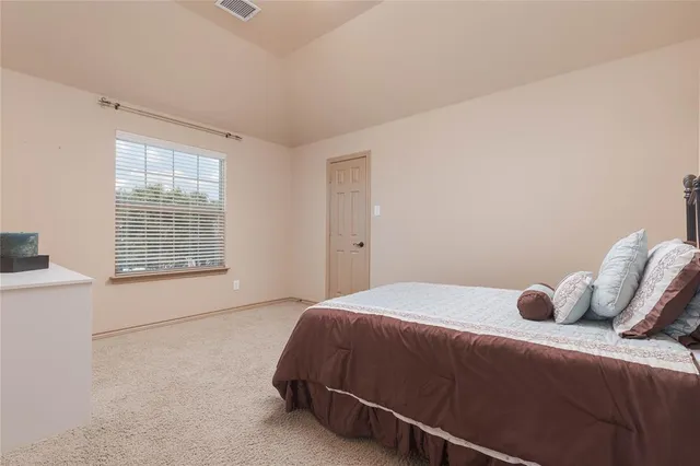 a bedroom with a bed and a large window