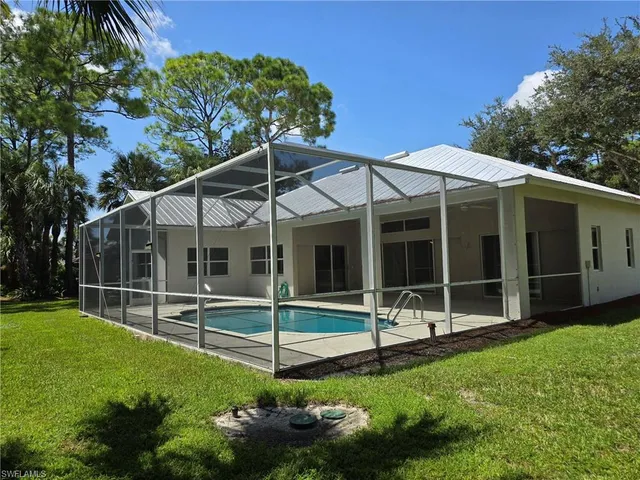a view of a chair and table in backyard of the house