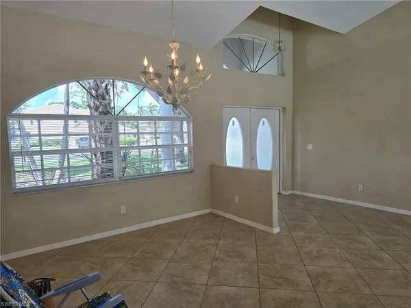 en empty room with windows and chandelier