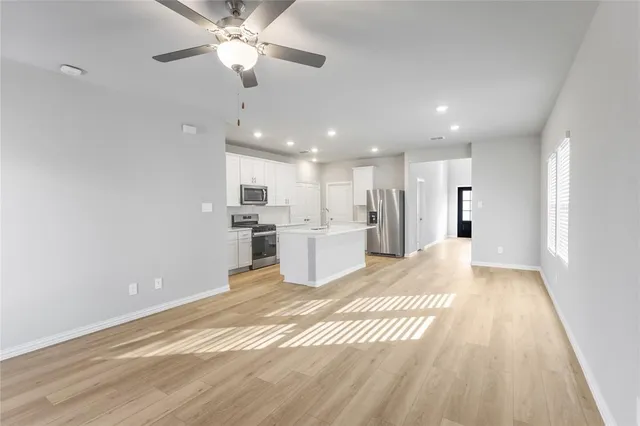 a view of a kitchen with refrigerator and a ceiling fan