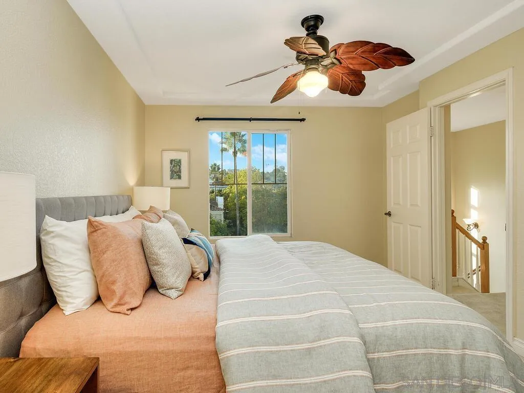2249 Historic Decatur Road, Unit 82 San Diego, CA 92106 - Photo 20 of 37 a bedroom with a large bed and a chandelier