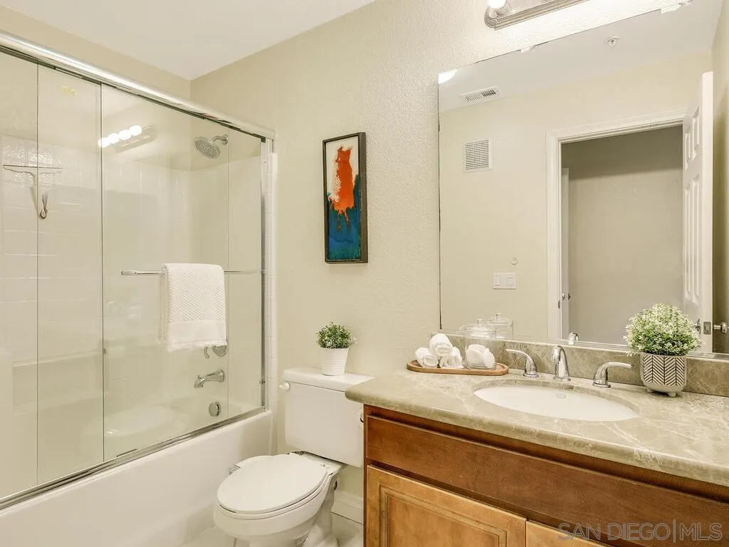 2249 Historic Decatur Road, Unit 82 San Diego, CA 92106 - Photo 21 of 37 a bathroom with a granite countertop sink toilet mirror and shower
