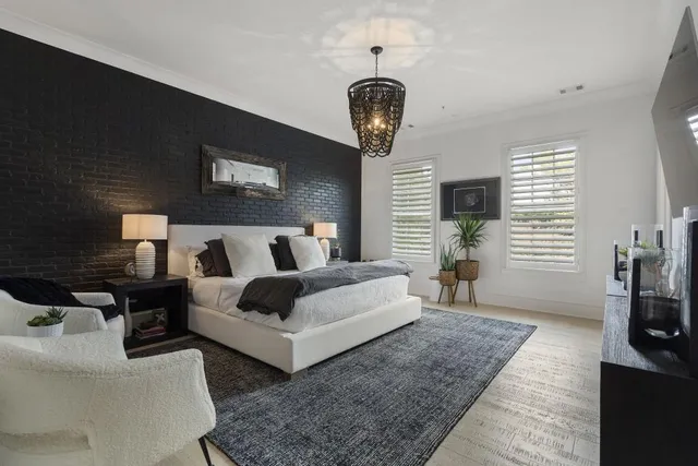 a spacious bedroom with bed and a flat tv screen