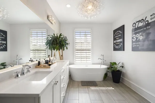 a bathroom with a double vanity sink a mirror and a bathtub