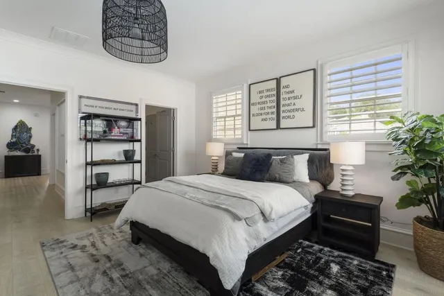 a bedroom with a large bed and a potted plant