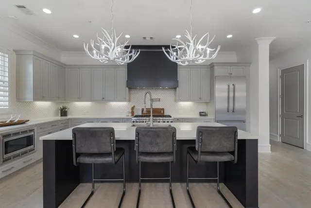 a kitchen with a dining table chairs stainless steel appliances and cabinets