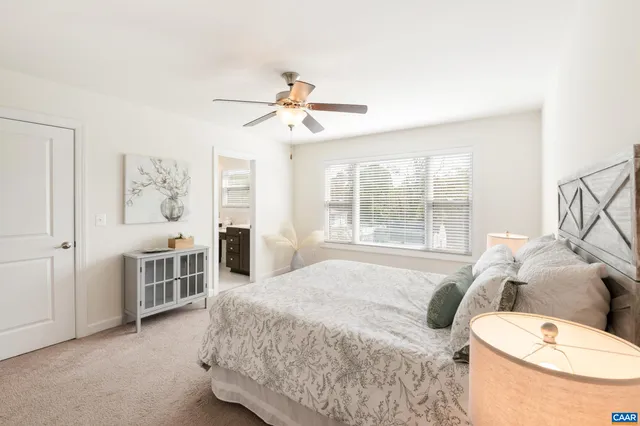 a spacious bedroom with a bed and a chandelier