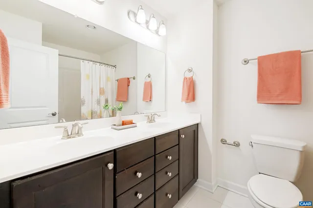 a bathroom with a sink vanity granite and toilet