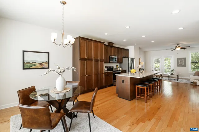 a kitchen with a table chairs refrigerator and microwave