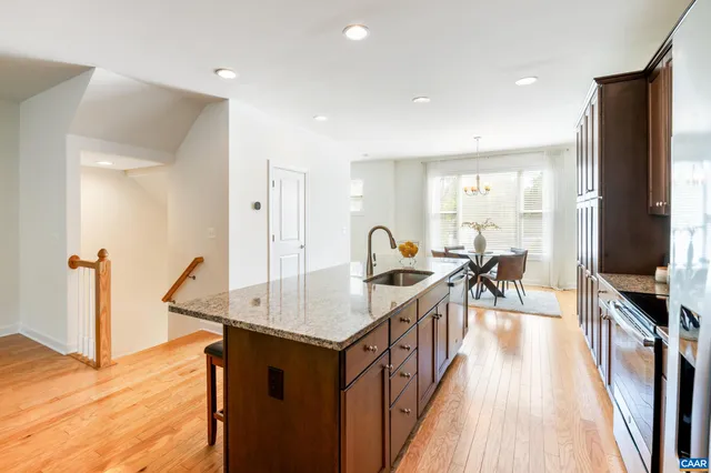 a kitchen with sink refrigerator and wooden floor