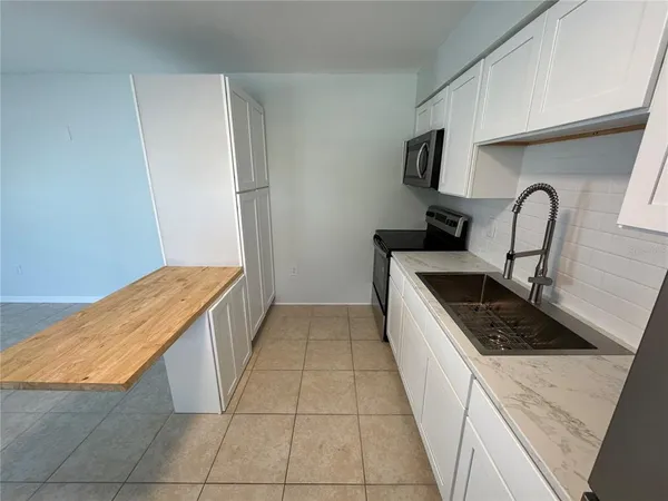 a kitchen with a sink a stove and cabinets