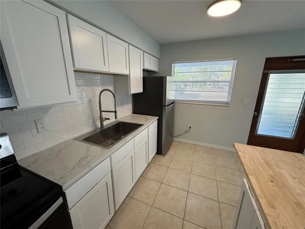 a kitchen with a sink cabinets and window