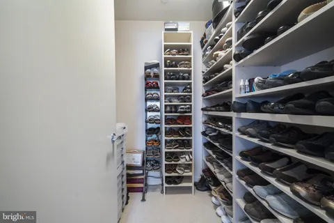 a view of walk in closet with clothes and shoes