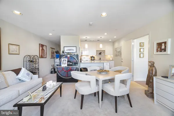 a kitchen with stainless steel appliances granite countertop a refrigerator a sink dishwasher a stove and white cabinets with wooden floor