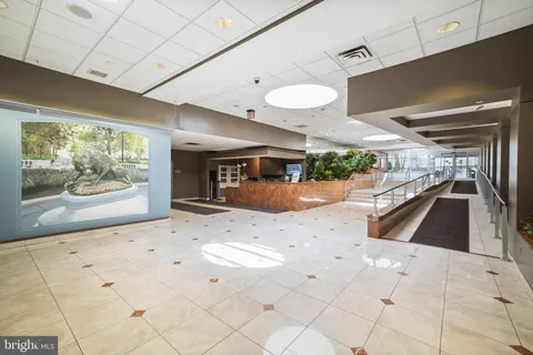 a large white kitchen with a large window and refrigerator