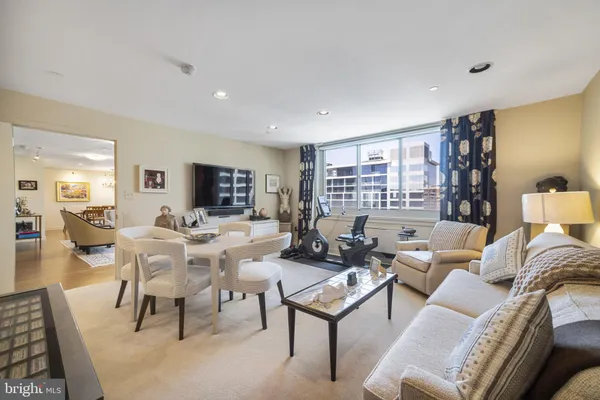 a living room with furniture a flat screen tv and a table