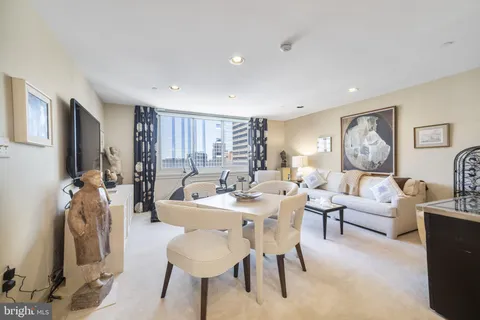 a living room with furniture a rug a lamp and a large window