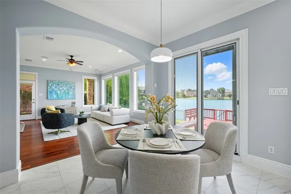 a living room with furniture large windows and a chandelier